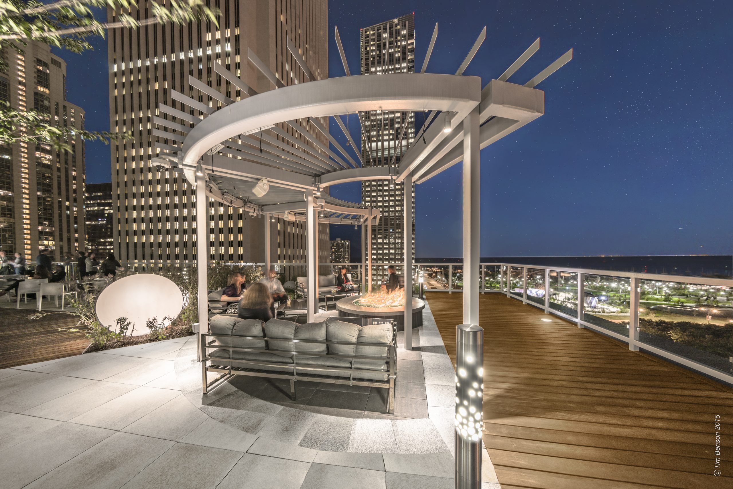 The Prudential Plaza boasts a modern aesthetic with an open-concept pergola, couch seating, a fire pit and large light grey Unilock slabs.