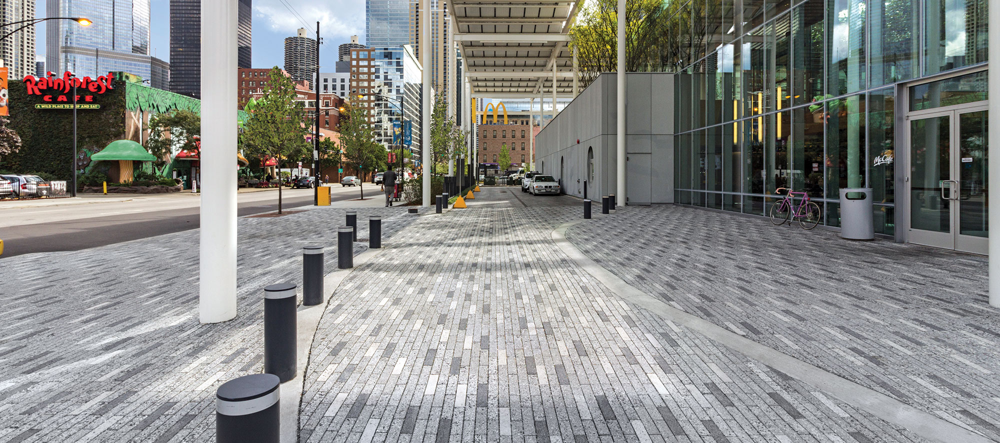 Eco-Promenade permeable pavers in different tones from white to dark grey with a speckled finish pave the sidewalk and roadway.