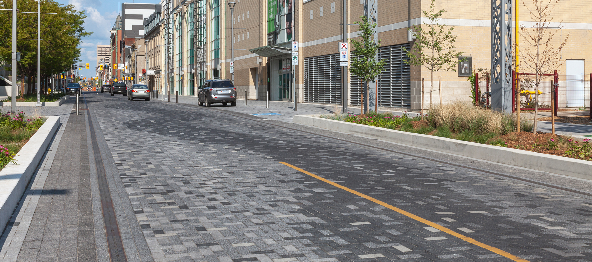 Dundas Place streetscape features Series pavers in pixelated patterns, a curvy zig-zag in the center, and garden beds on either side.